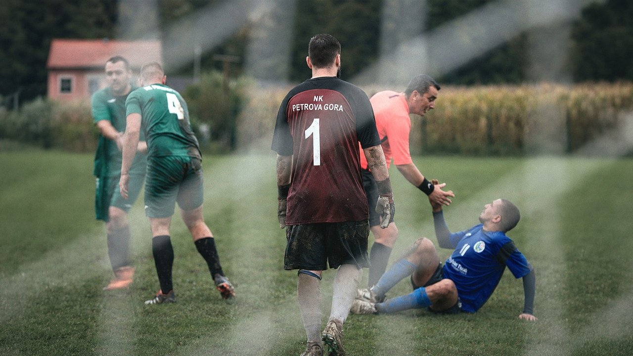 A referee offering a hand to a player on the ground