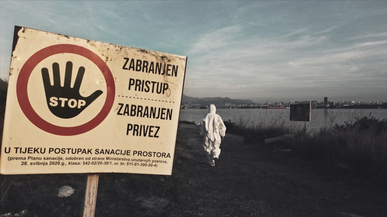 A warning sign and a figure in protective clothing