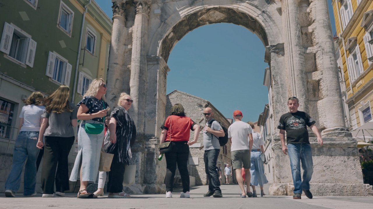 Tourists beneath the Arch of the Sergii in Pula
