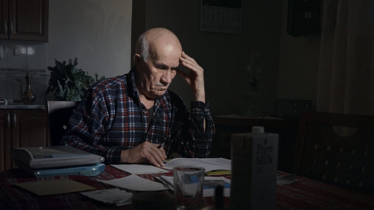 A man seated at a table with documents